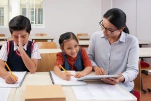 Cheerful woman teaching kids in class